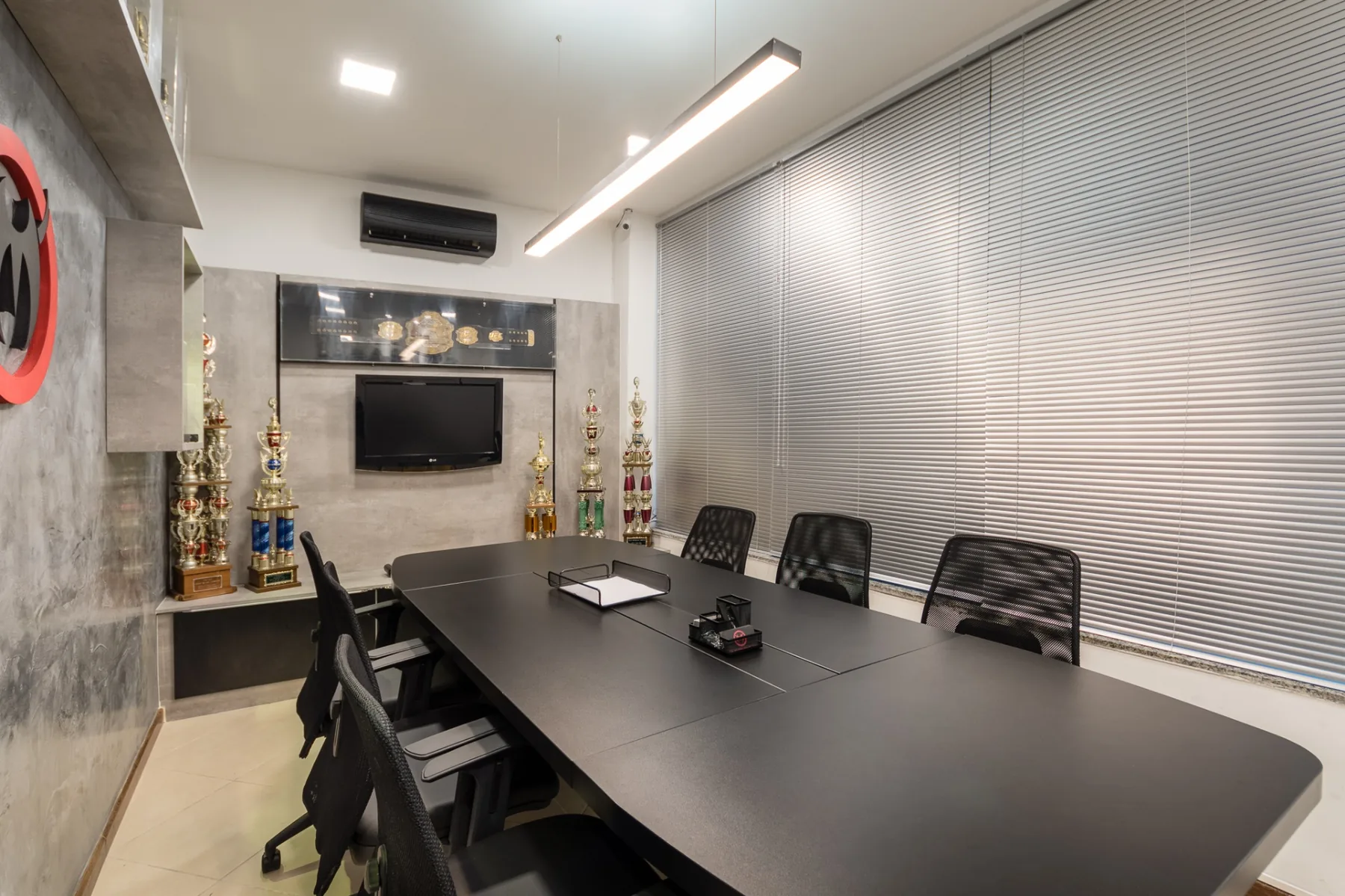 Sala de reunião do Team Nogueira com identidade da marca aplicada na parede